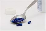 Blue pills at a spoon