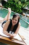 Woman in bikini relaxing on a deck chair.