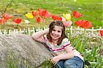 Little Girl Smiling in Front of Flowers