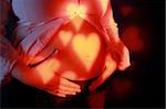 Pregnancy - woman belly with lights of hearts