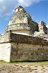 Antique maya observatory over blue sky and green grass