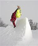 Snowboarder putting down a stylish handplant on a small improvised quarterpipe