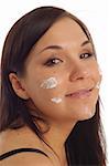 attractive brunette woman applying cream on white background