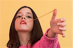 Young girl stretching a chewing gum from her mouth