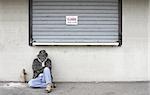 Man sleeping on the street by a closed business