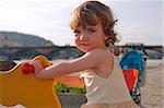 A playful little girl is rocking on the playground.