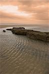 mud banks on the west coast of ireland near ballybunion under a red sky