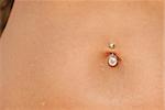 Piercing in a navel. A female body with a jewel - piercing