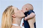 Mother Holding Son Up Kissing Him on Cheek