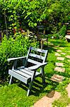 Path of stepping stones leading into lush green garden