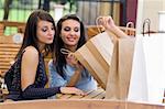 nice brunette showing her purchases just done to another pretty girls