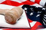 An open law book and a judges gavel on an American flag.