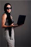 Portrait of young fashion female holding laptop