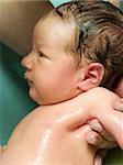 new-born baby taking a bath wet hand