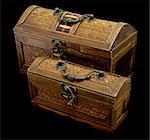 Two ancient chests with iron handles on a dark background
