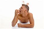 laying muscular man going to eat apple on an isolated background