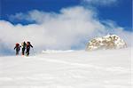 A group of backcountry skiers walks up to the top of the mountain in the blizzard, italian alps, europe.