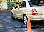 Teen driver backs up, doing the parking portion of her driving test.