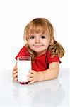 Happy little girl with a glass of milk reflected on a white table - isolated