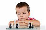Concentrated little boy solving a problem playing chess - isolated