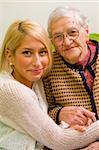 An old woman and her grandchild sitting close to each other (focus on the young woman) - part of a series.