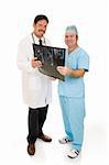 Doctor and surgeon reviewing MRI test results together.  Full body isolated on white.