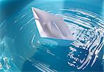 Toy paper ship floating in blue water