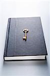 A hardcover book with a golden key on it.