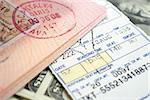 airplane ticket and passport on american dollars