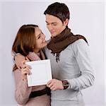 young attractive couple smiling hugging and holding with blank sign isolated on white