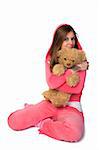 Young beautiful woman in the pink sportswear sitting with teddy bear over white background