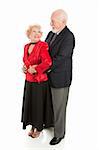 Romantic senior husband holds his wife close as they dance together.  Full body isolated.