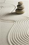 Stack of stones on raked sand; zen concept