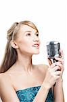 Pretty young girl singing into retro microphone, on white