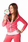 Young beautiful woman in the pink sportswear sitting with lollipop over white background