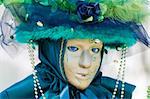 Carnival in venice with model dressed in various costumes and masks - green lady