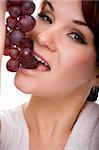 attractive woman with grapes. over white background