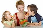 Woman feeding kids with vegetables - isolated