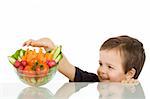 Happy boy stealing from the vegetables bowl - isolated