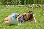 pretty girl working on laptop in a sunny day outdoor in the park