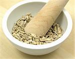 Pestling sunflower seeds in a bowl of chinaware