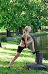 cute girl stretching her body in a park one sunny sunday morning