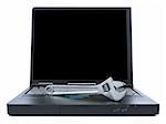 A spanner over a black laptop isolated over white background. Black copy space on screen.