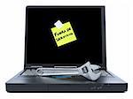 Laptop with a sticky note in spanish meaning Out of Service and a spanner over the keyboard. Isolated on white.