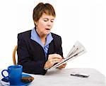 Pretty mature businesswoman circling job listings in the newspaper. Isolated on white.