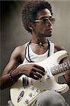 Portrait of young african man playing electric guitar