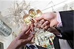 several hands toasting with champagne on new years eve