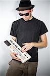 cool guy with hat playing on tiny keyboard