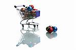 shopping cart full with colorful christmas balls isolated on white background