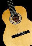 Neck and head of an acoustic guitar, isolated black background with copy-space